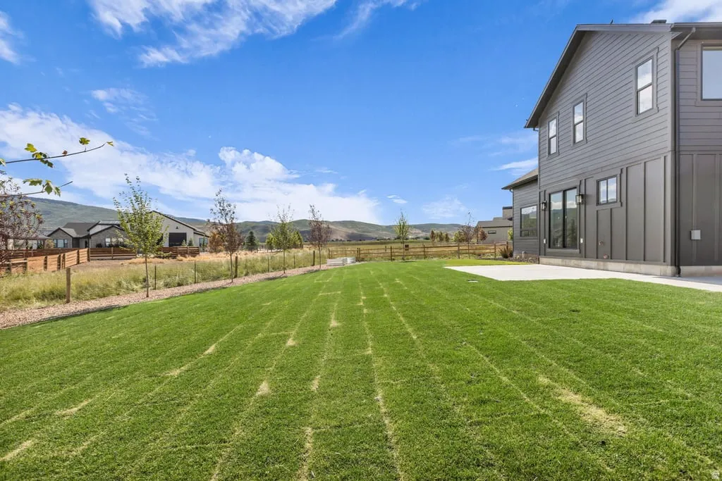 Expansive green lawn with a concrete patio