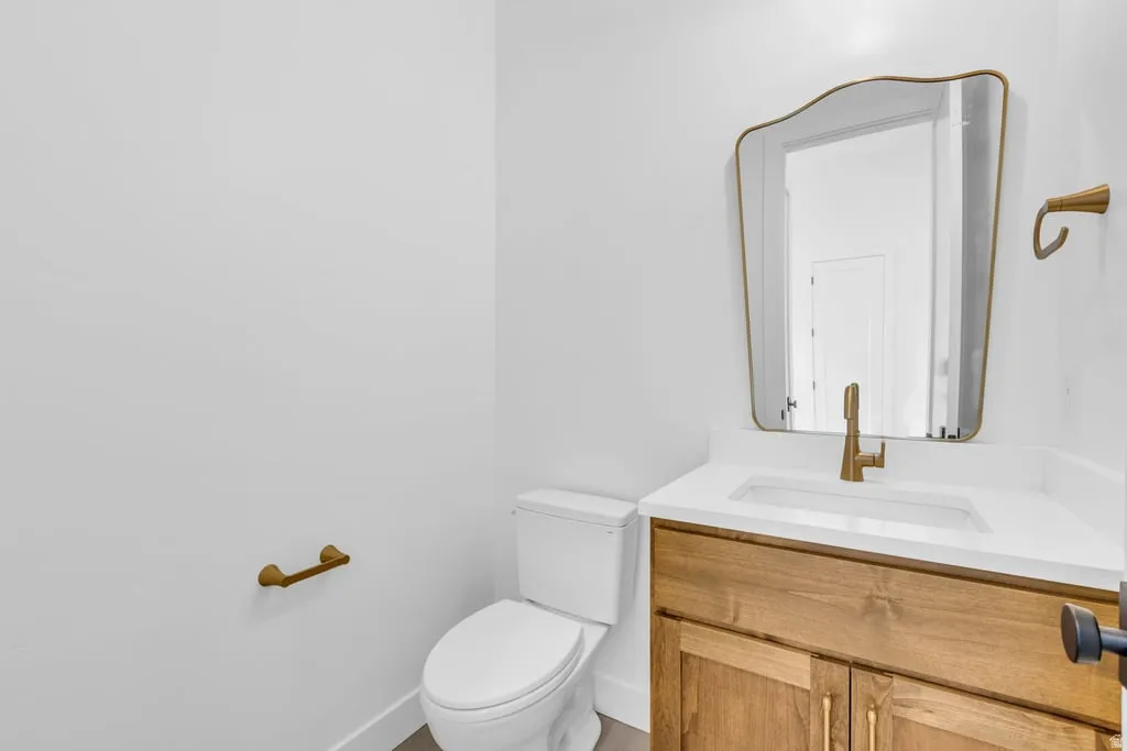 Bathroom vanity featuring a quartz countertop, integrated sink, and wood-finish cabinetry