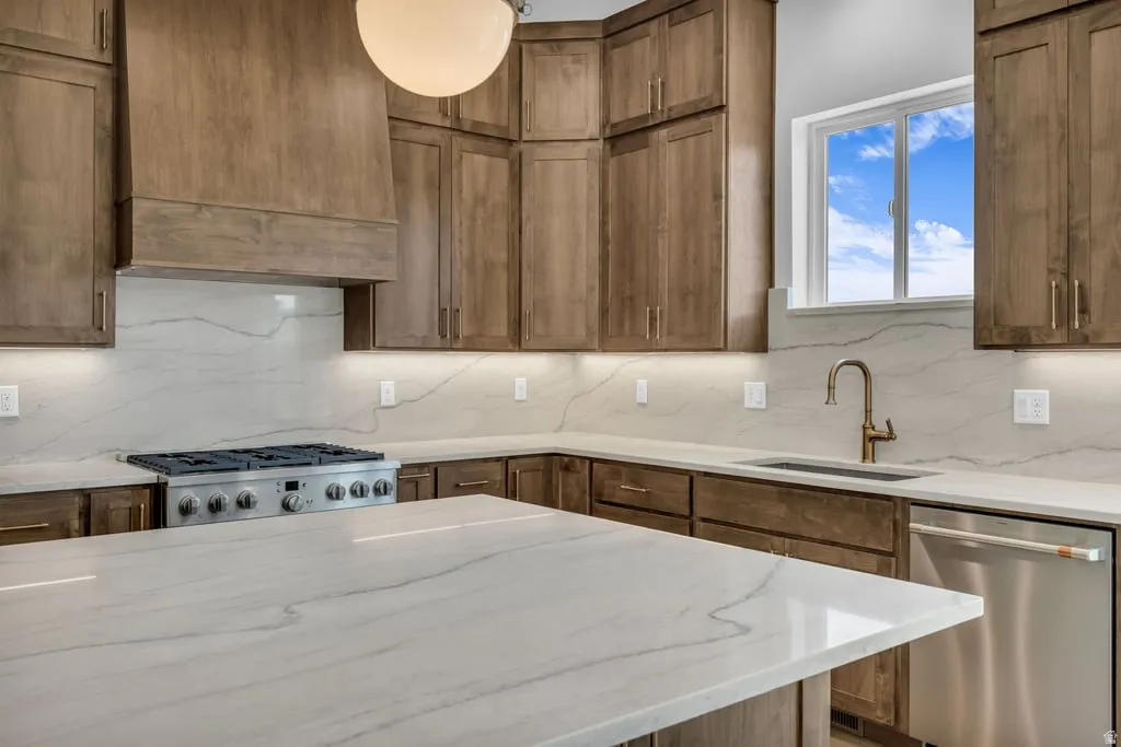 Kitchen featuring wood cabinetry, a stainless steel gas range, and a brass-finish faucet
