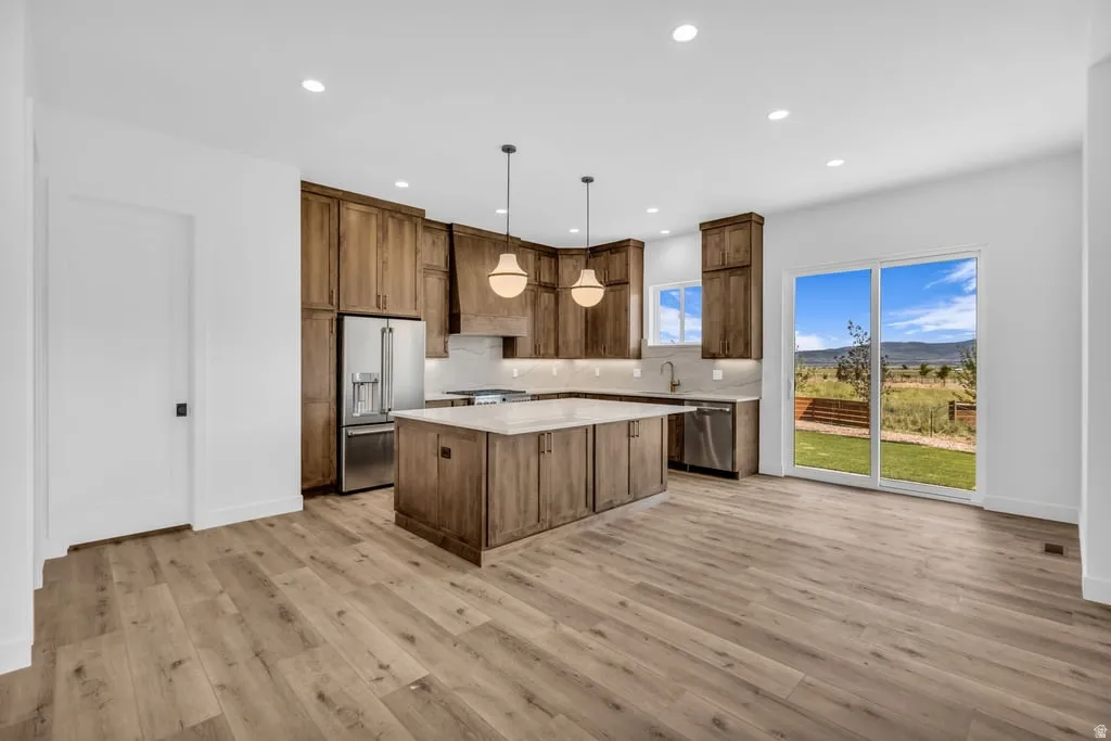 Modern kitchen featuring rich wood cabinetry, stainless steel appliances, and a central island with a light-toned countertop