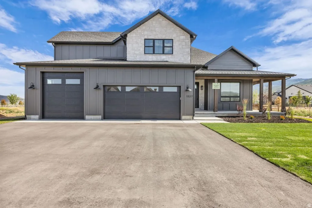 Modern farmhouse exterior featuring gray vertical siding and stone accents