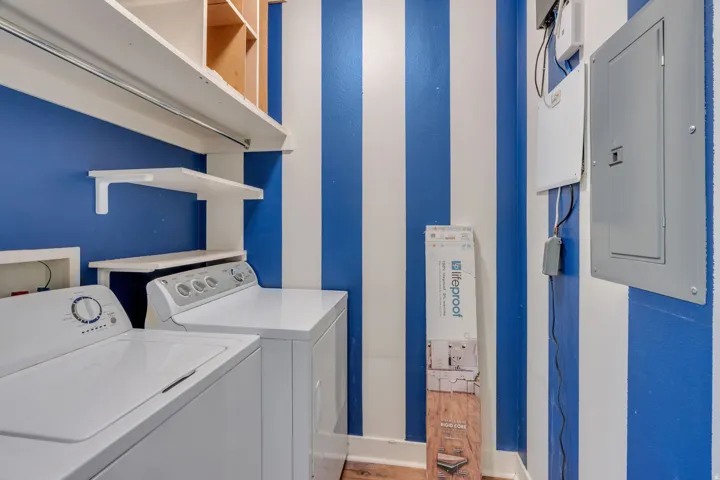 Built-in shelving with hanging rod, additional wall-mounted shelving, and wood-finish flooring