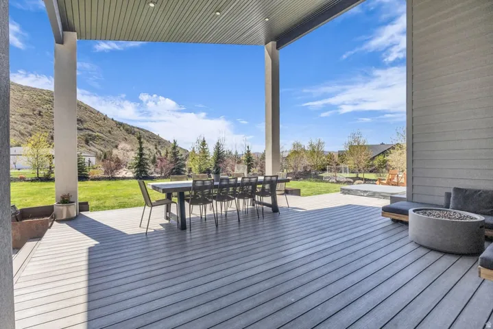 Expansive covered deck featuring composite decking, recessed lighting, and support columns