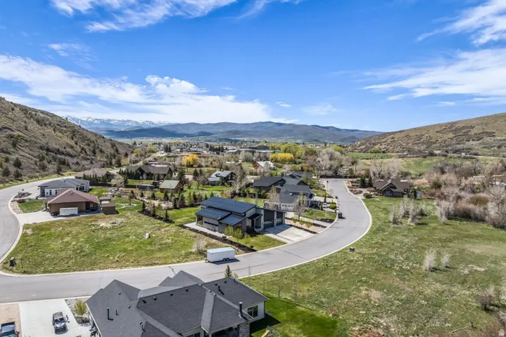 Mountainous landscape featuring a residential area with varied home styles and green spaces