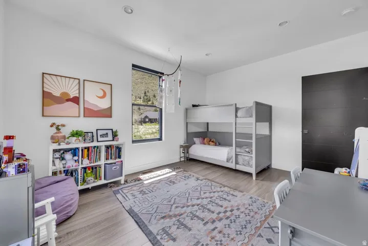 Bright room featuring light wood-finish flooring, white walls, and recessed lighting