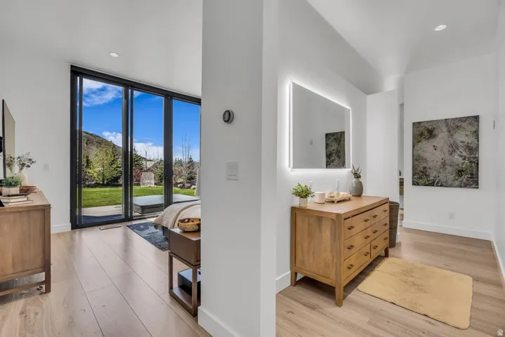 Expansive glass doors opening to a lush green lawn