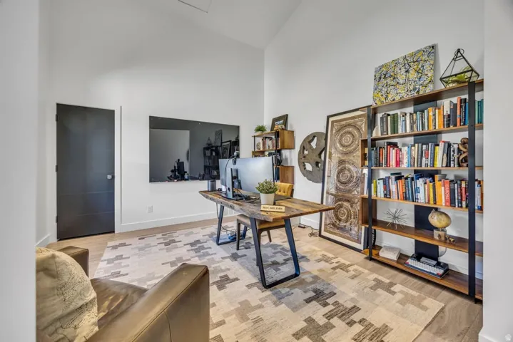 Vaulted ceiling interior space with light-toned wood-finish flooring