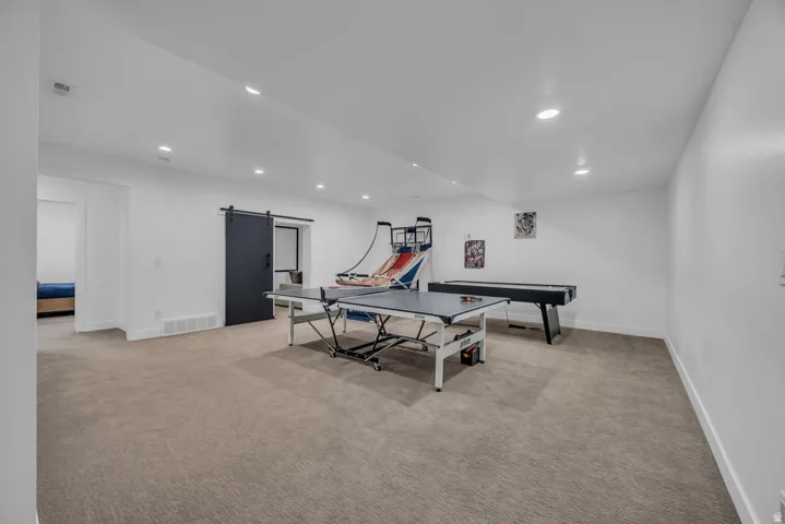 Expansive carpeted room featuring recessed lighting and white walls