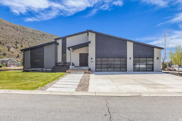 Modern dwelling featuring a sloped roofline and a two-car garage with frosted glass doors