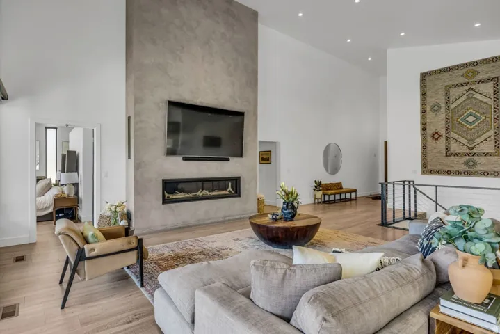 Expansive living space featuring a floor-to-ceiling textured accent wall, integrated linear fireplace, and recessed lighting