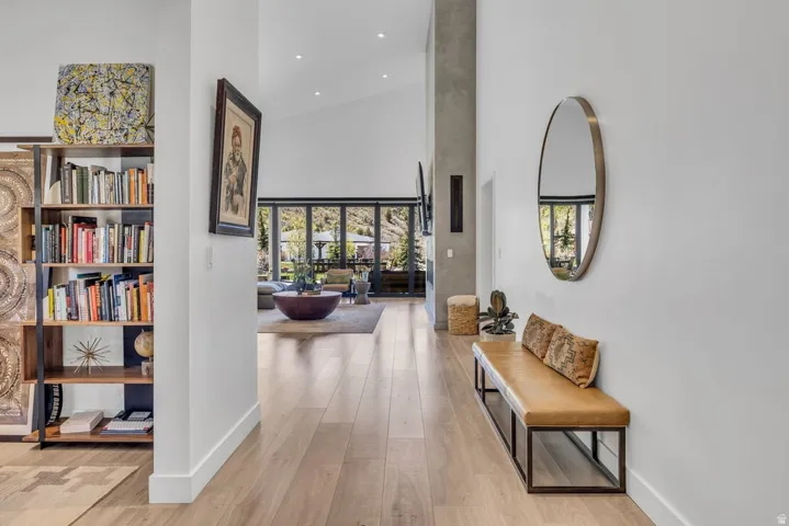 Spacious entry hallway featuring wood-finish flooring, a built-in shelving unit, and a vaulted ceiling