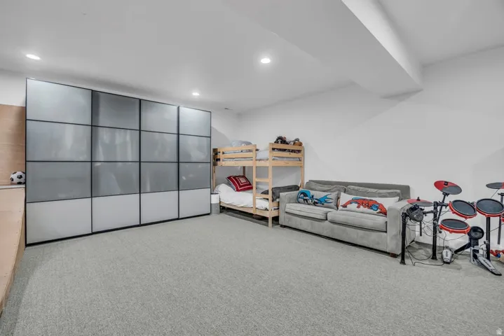 Expansive room featuring light gray carpeting and recessed lighting