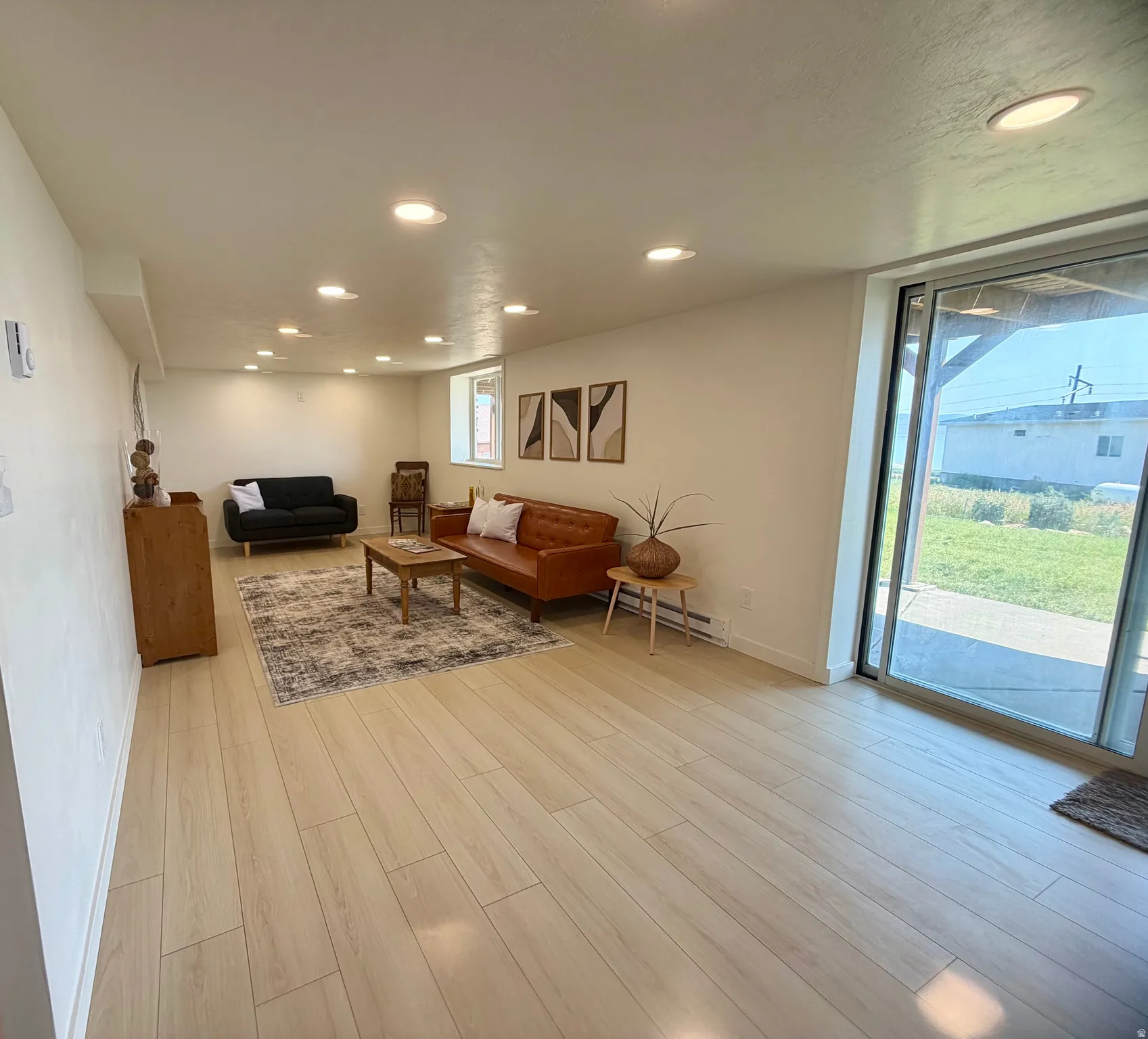 Spacious room featuring wood-finish flooring and recessed lighting