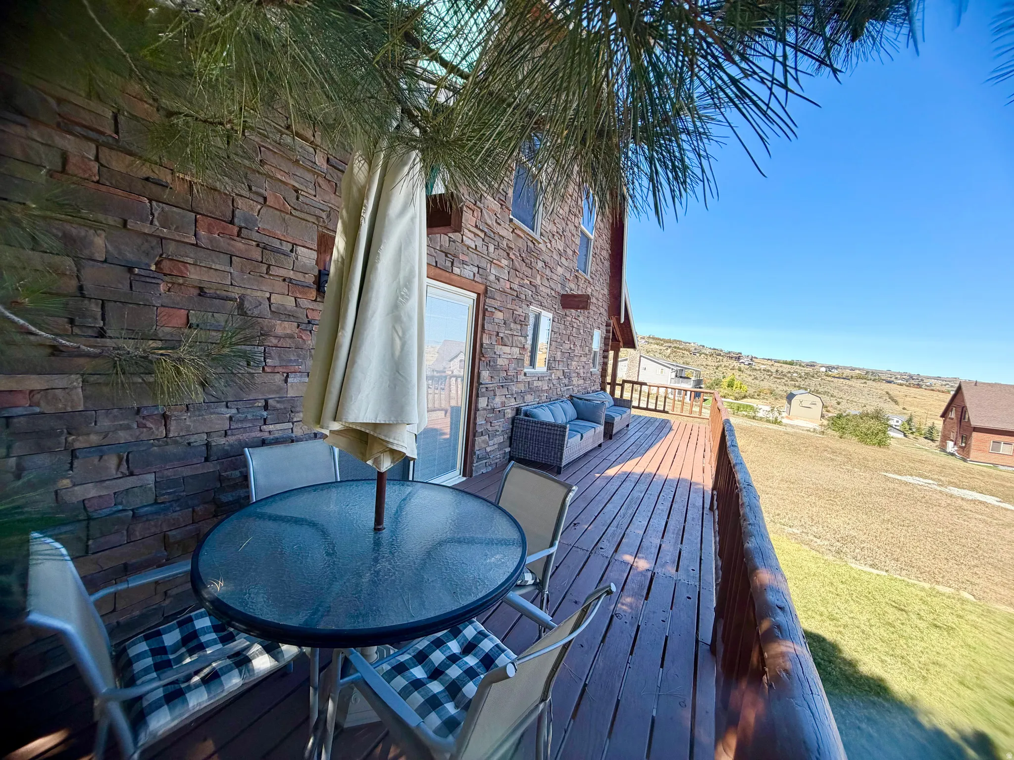 Spacious exterior deck with wood-finish flooring and a natural wood railing