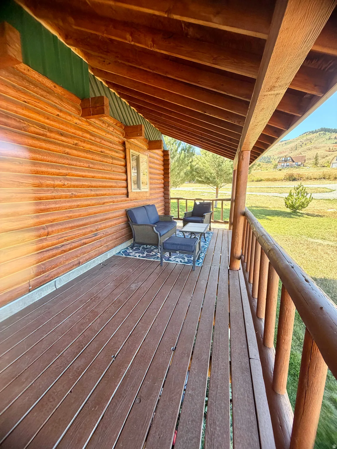Spacious covered porch with wood-finish decking and wood railing