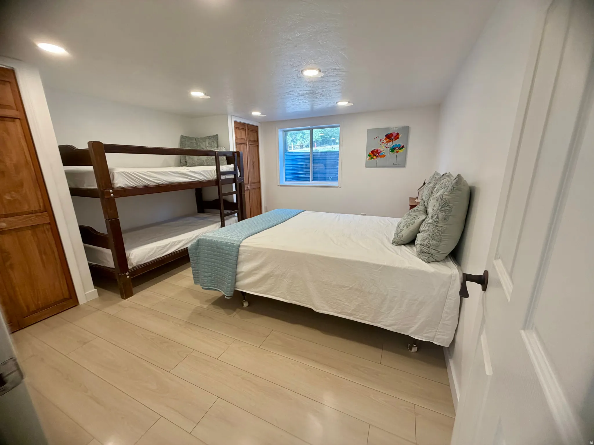 Spacious room featuring light wood-finish flooring and white walls