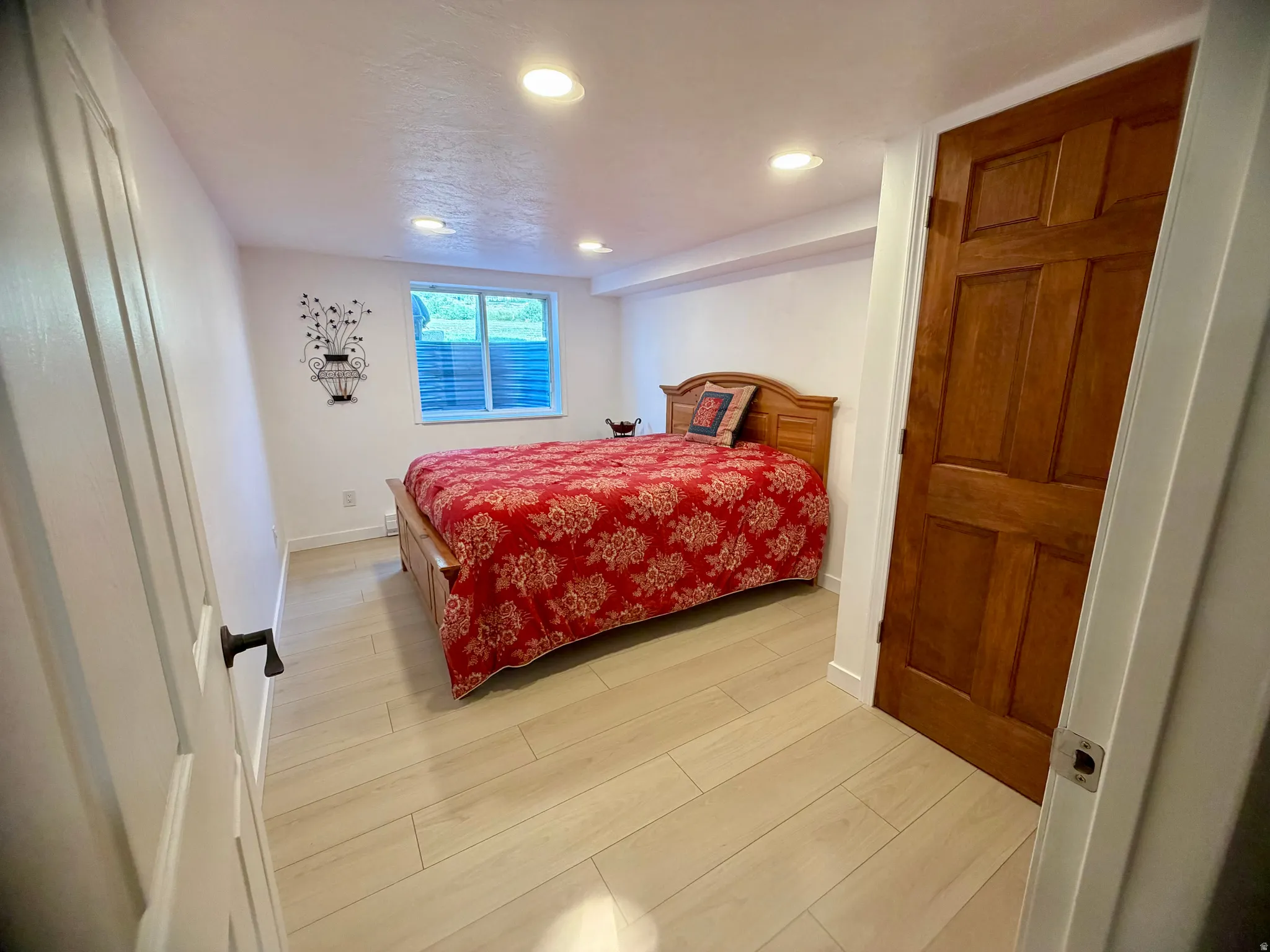 Bedroom featuring light wood-finish flooring, recessed lighting, and a window with blinds