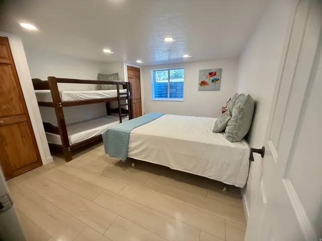 Spacious room featuring light wood-finish flooring and white walls