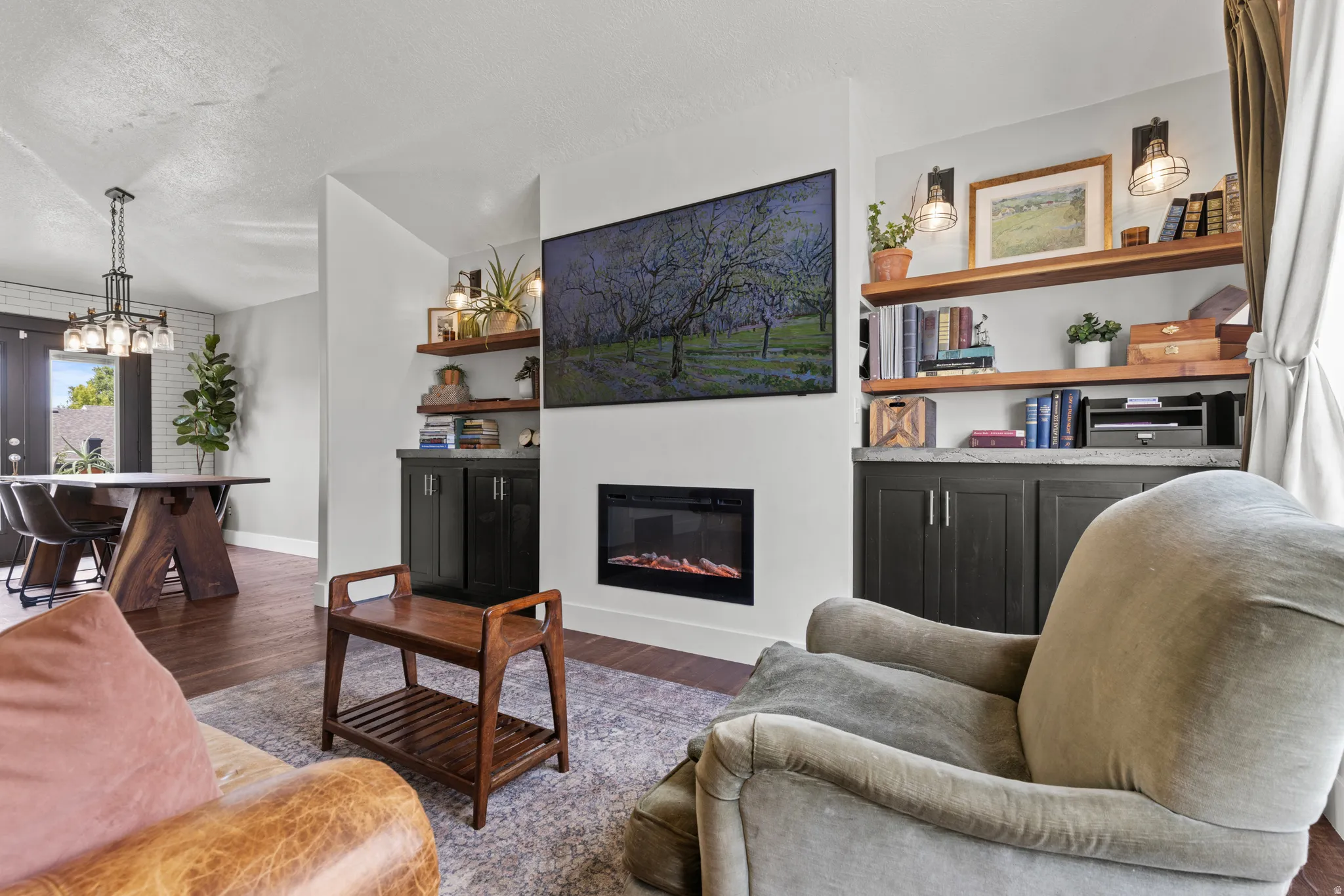 Living area featuring a built-in fireplace, wall-mounted display, and custom shelving