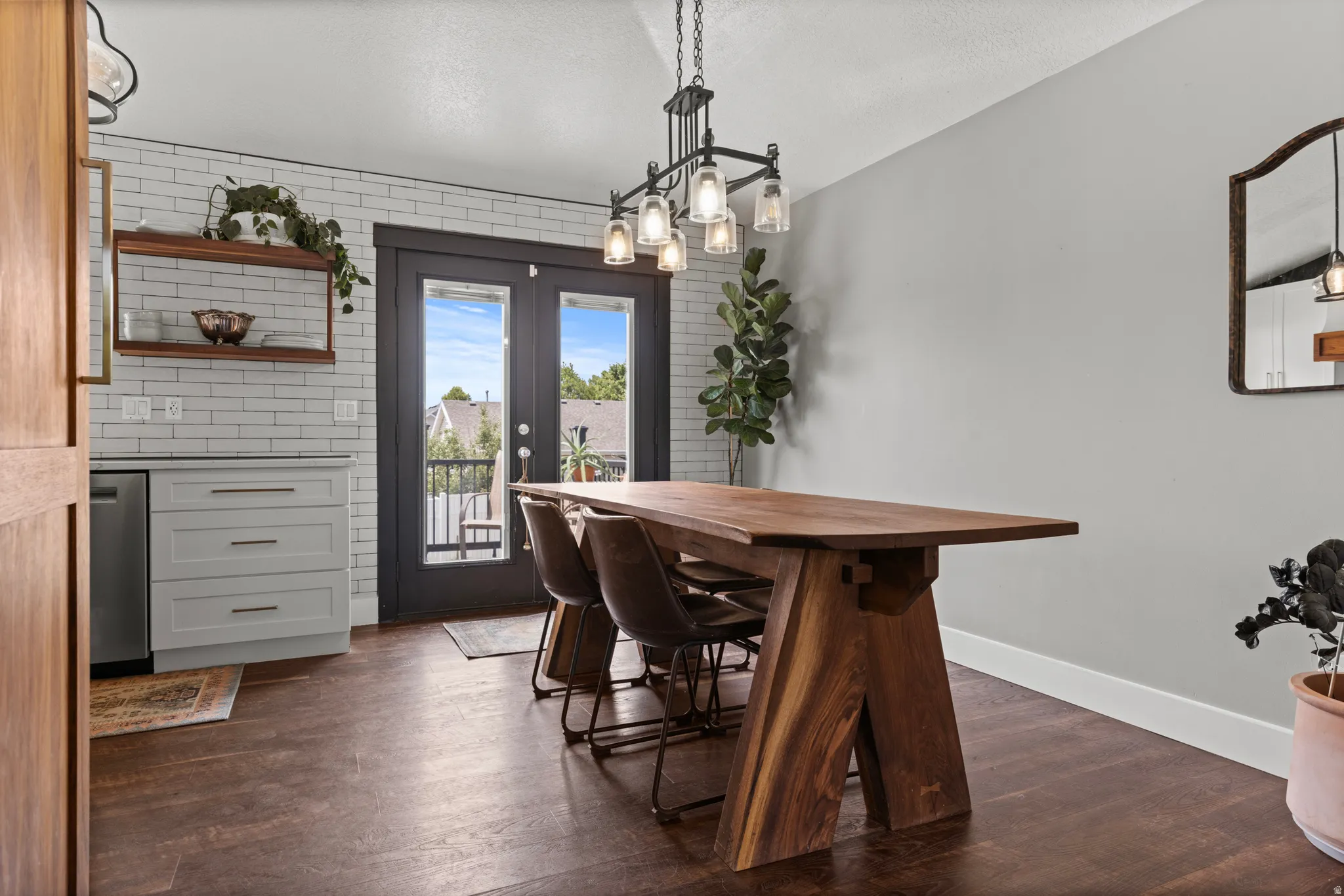Dining space featuring wood-finish flooring and a contemporary linear chandelier
