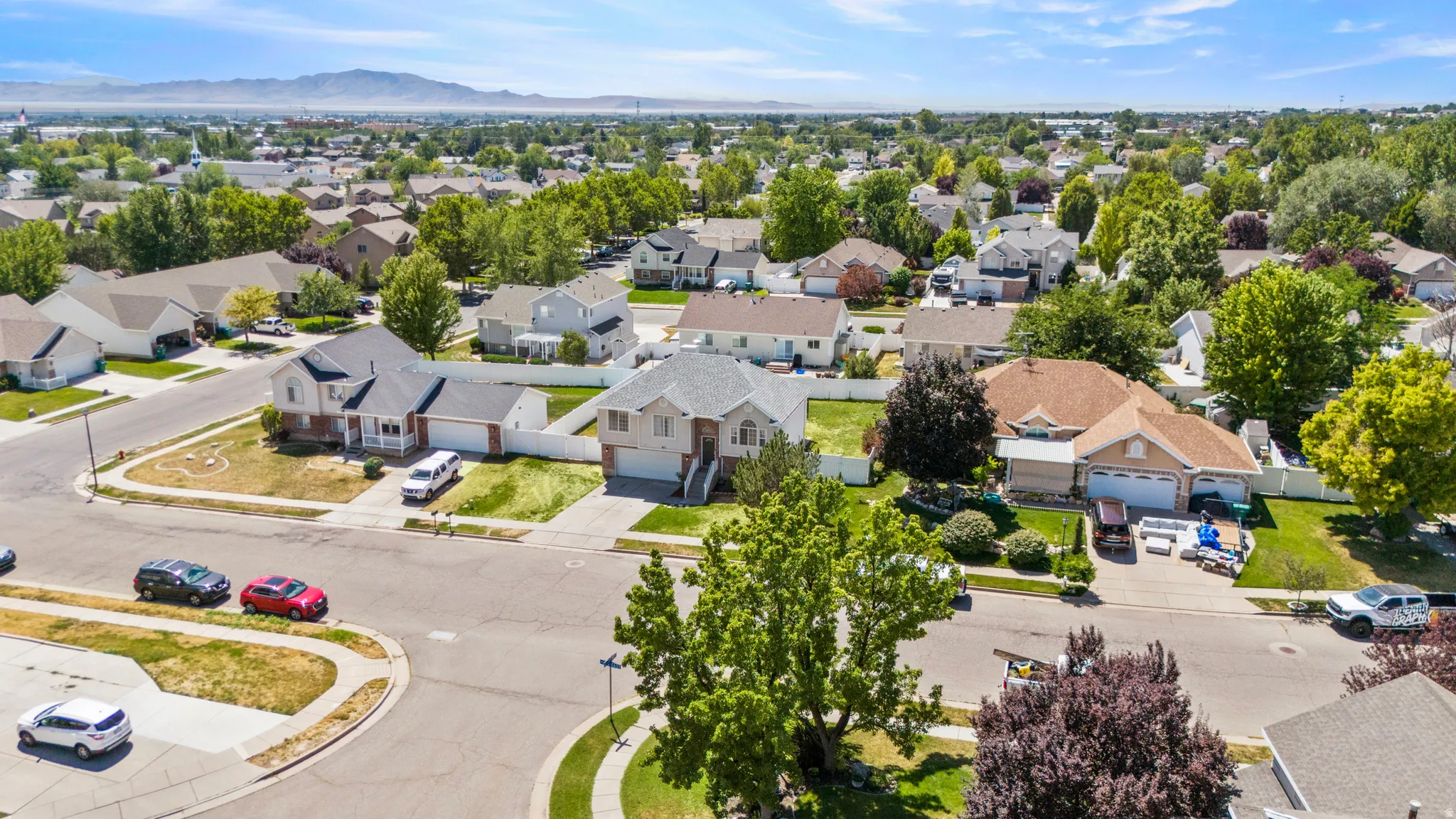 Residential neighborhood featuring mature trees and mountain scenery