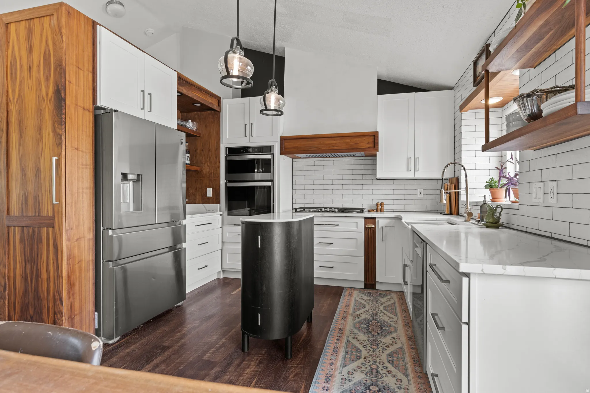 Contemporary kitchen featuring a vaulted ceiling and dark wood-finish flooring