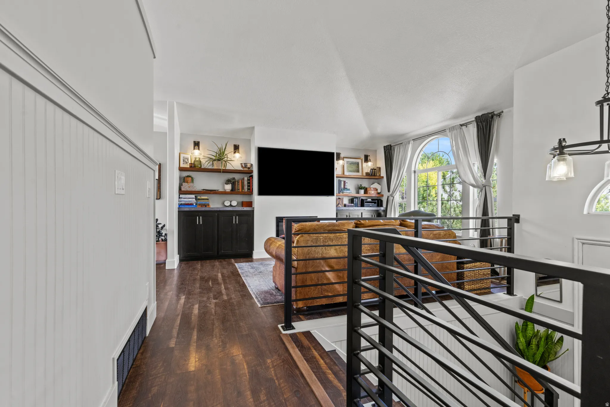 Vaulted ceilings complement wood-finish flooring throughout this living space