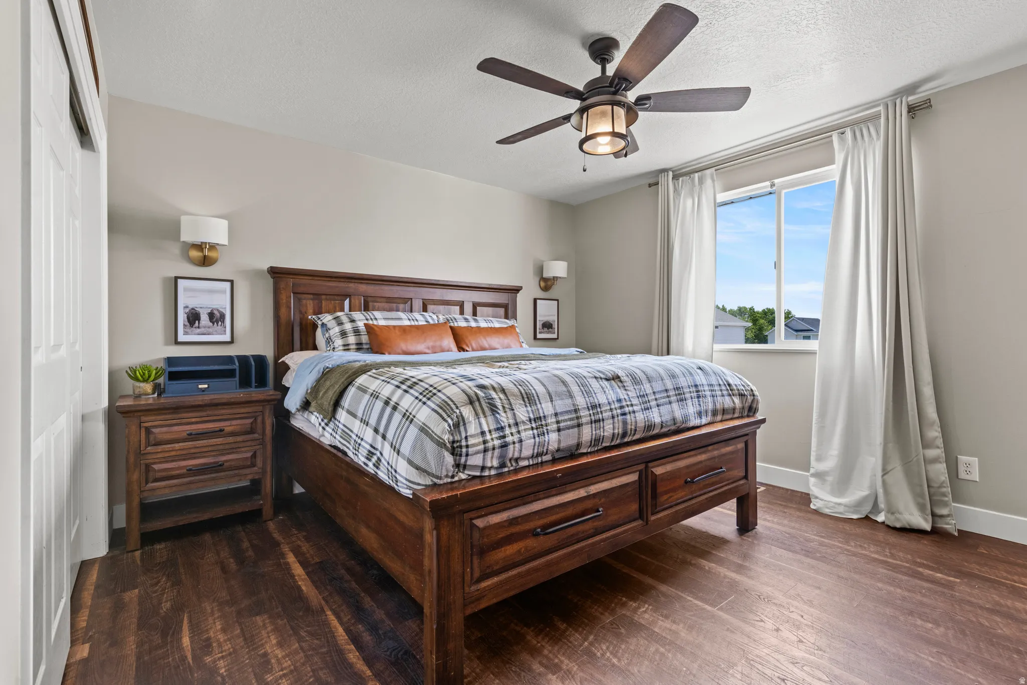 Bedroom featuring wood-finish flooring, a ceiling fan with integrated lighting, and a large window