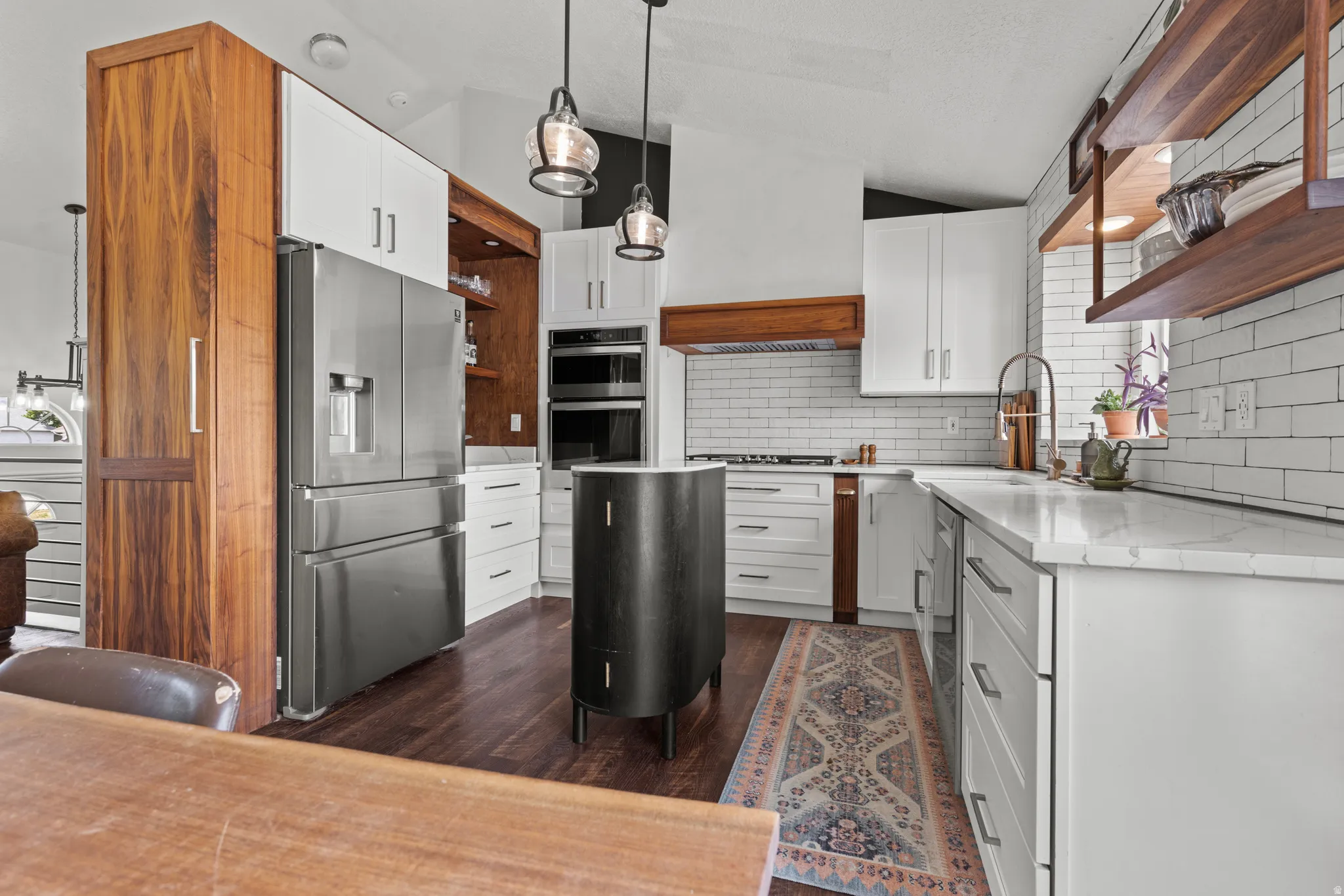 Modern kitchen featuring white cabinetry, stainless steel appliances, wood-finish flooring, subway tile backsplash, and stone countertops