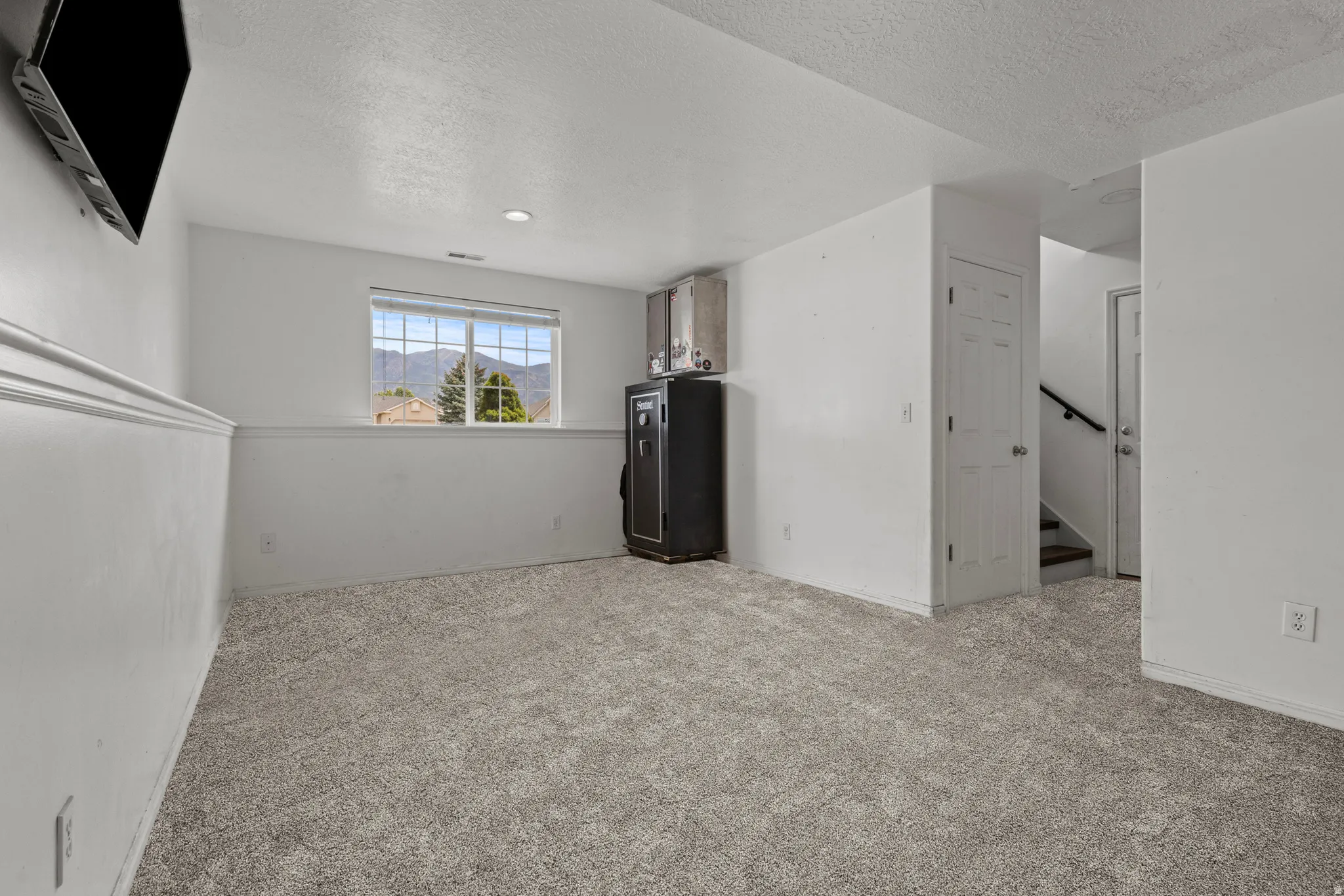 Carpeted room with a double-hung window featuring mountain scenery, recessed lighting, and a chair rail molding detail. *Carpet is photoshopped in, ment to match new carpet.