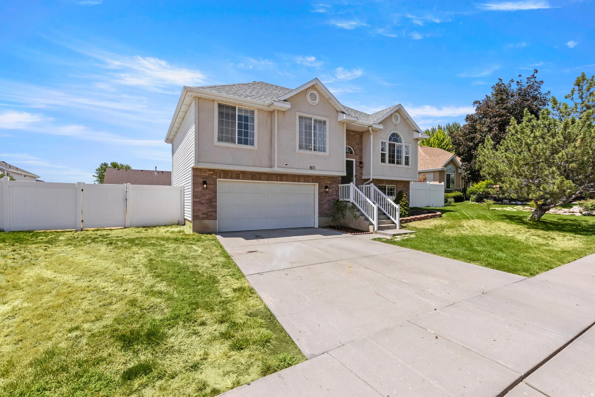 Two-story residence featuring a brick and stucco exterior, an attached two-car garage, and a concrete driveway