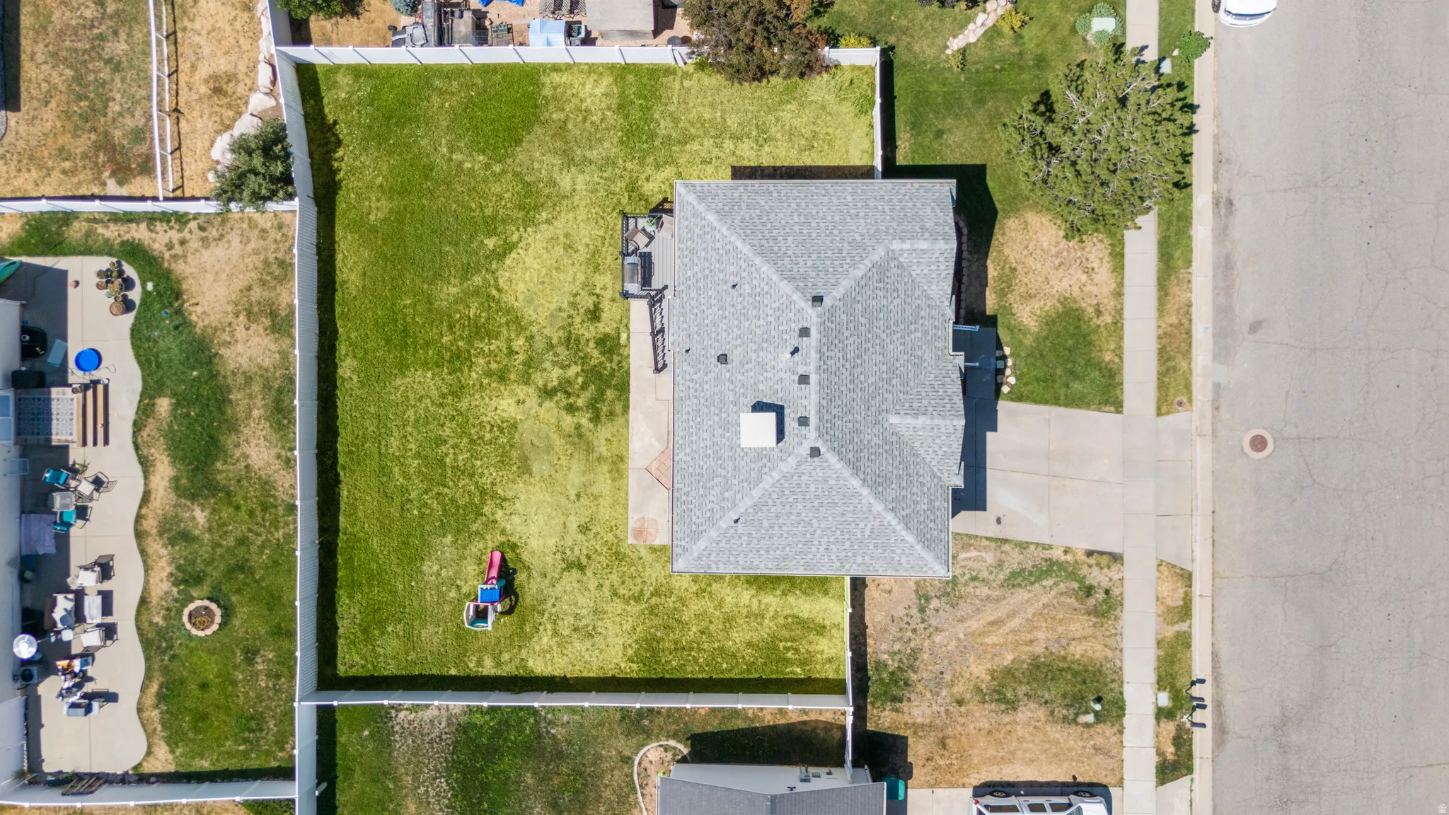 Expansive fenced backyard with a green lawn