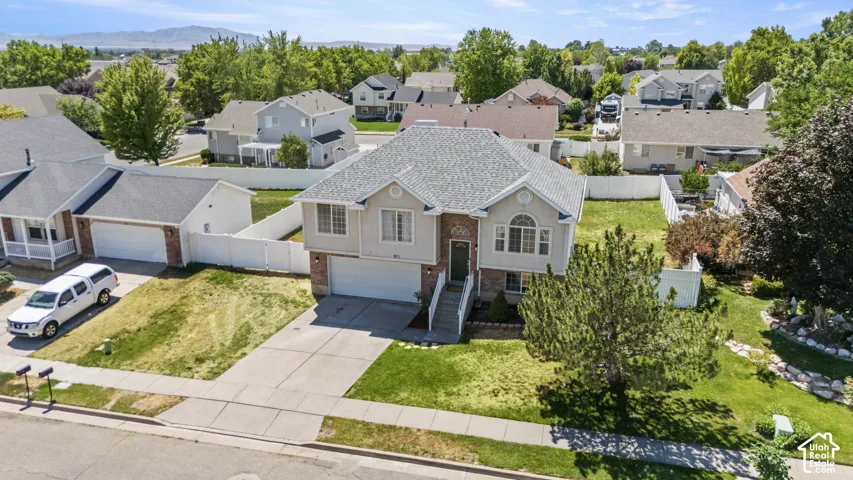 Traditional two-story residence featuring a front-facing attached garage, stone accents on the facade, a bay window, and a prominent front entrance staircase