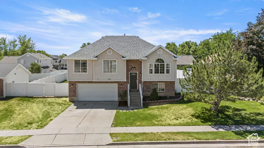 Two-story residential property featuring a gray shingle roof, light-colored siding, and brick accents
