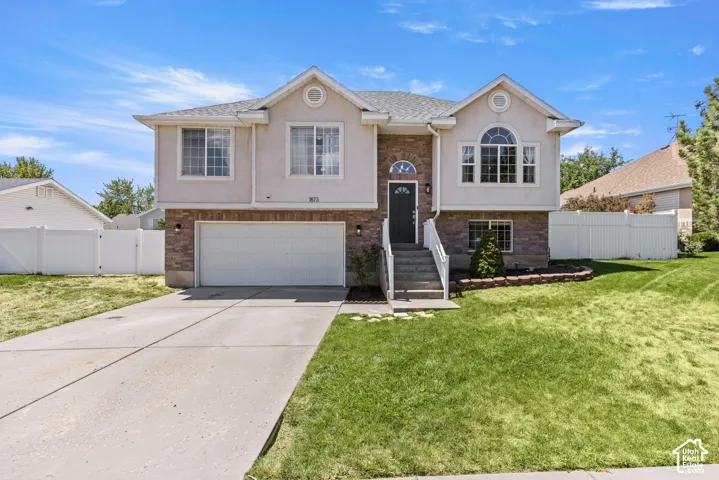 Two-story residence featuring a brick and stucco exterior, an arched window, an attached two-car garage, and a concrete driveway