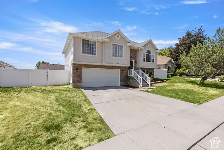 Two-story residence featuring a brick and stucco exterior, an attached two-car garage, and a concrete driveway