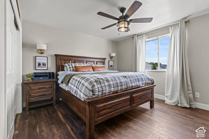 Bedroom featuring wood-finish flooring, a ceiling fan with integrated lighting, and a large window