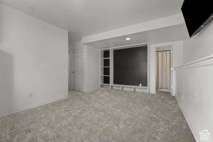 Carpeted room featuring a built-in media center with shelving, recessed lighting, and a neutral color palette. *Carpet is photoshopped in, ment to match new carpet.
