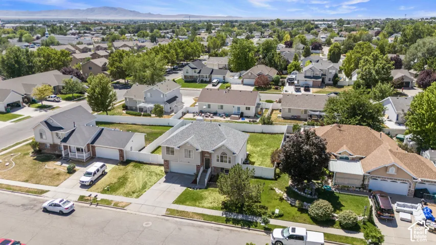 Suburban residential area featuring established homes, mature trees, and mountain scenery in the background