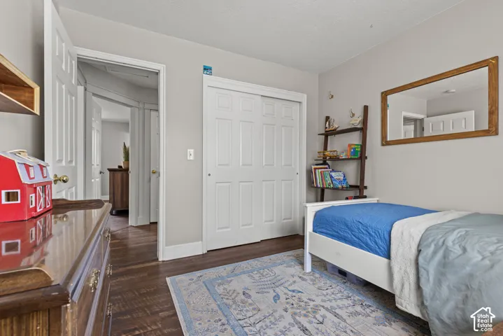 Spacious interior room featuring wood-finish flooring, light neutral wall paint, and white trim