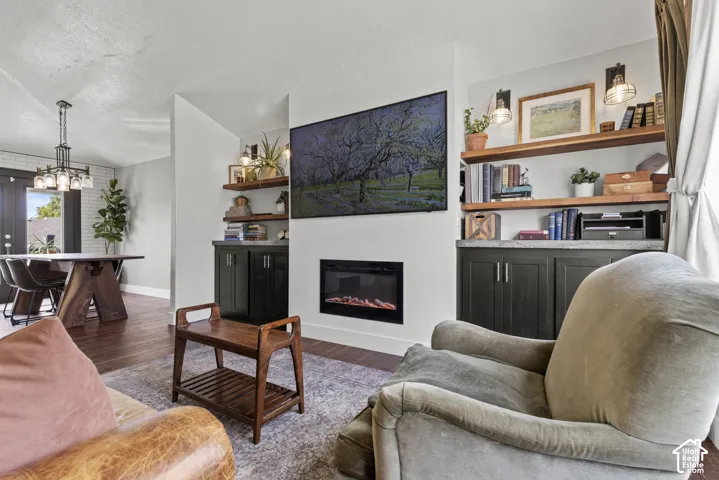 Living area featuring a built-in fireplace, wall-mounted display, and custom shelving