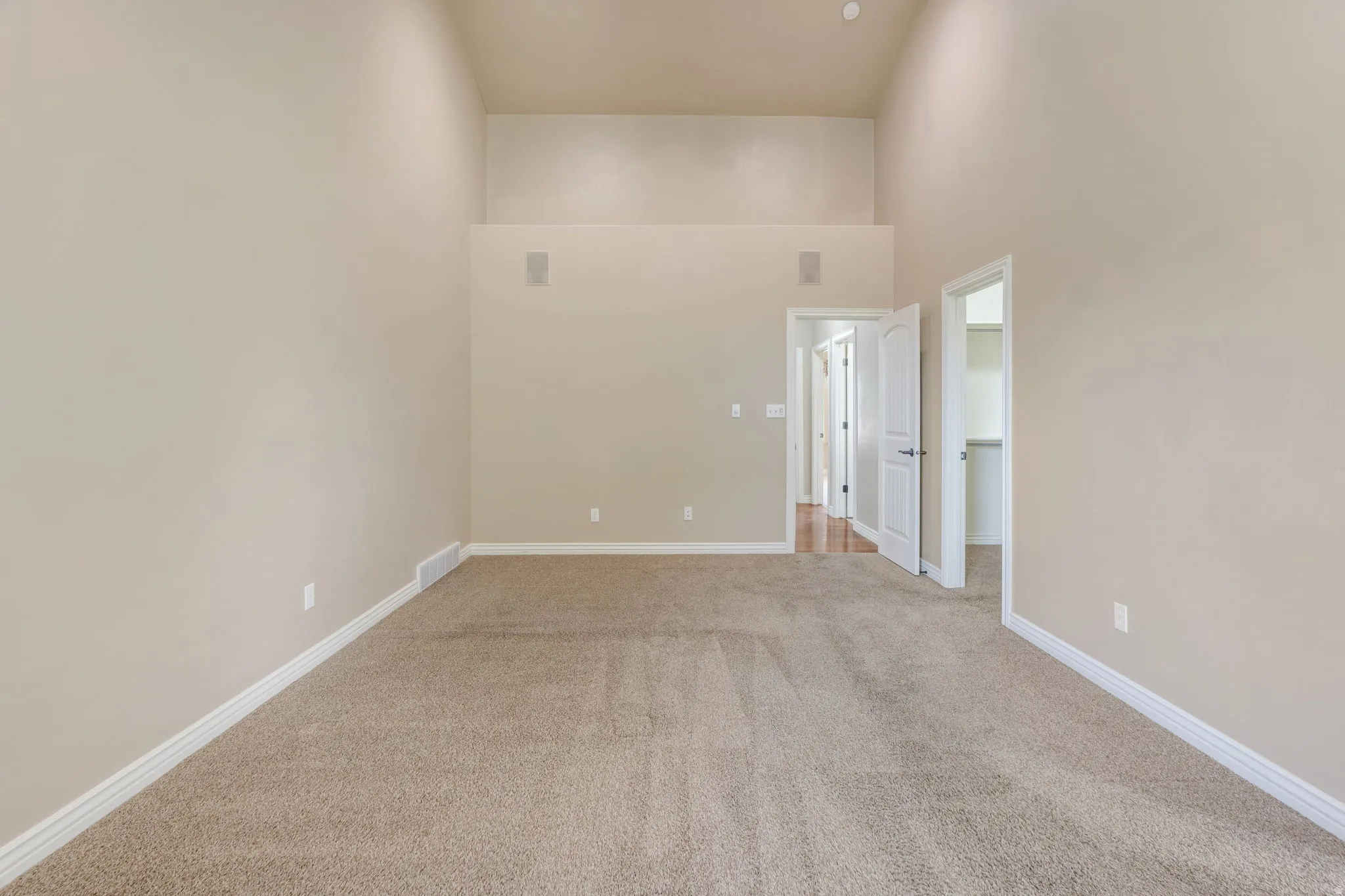 Vaulted ceilings, neutral carpet flooring, recessed lighting, and integrated wall speakers