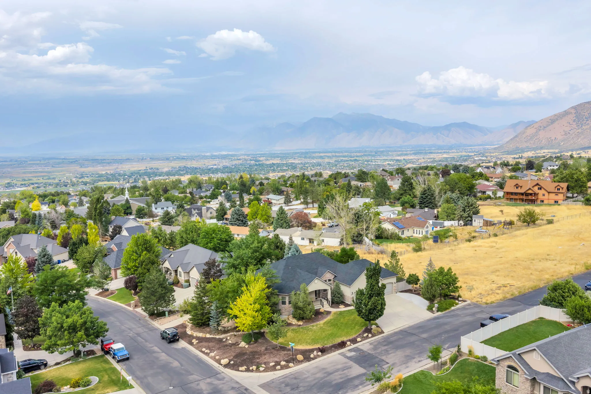 Expansive residential area featuring established homes, mature trees, and mountainous terrain