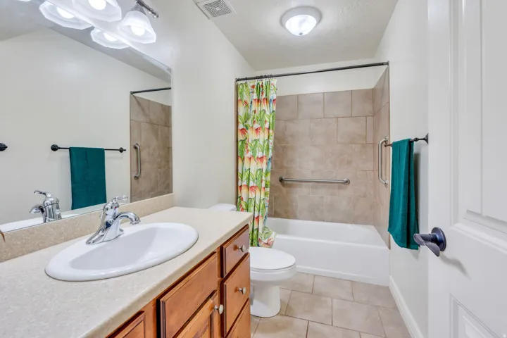 Bathroom featuring a single vanity with wood cabinetry, a built-in sink, and a light-colored countertop