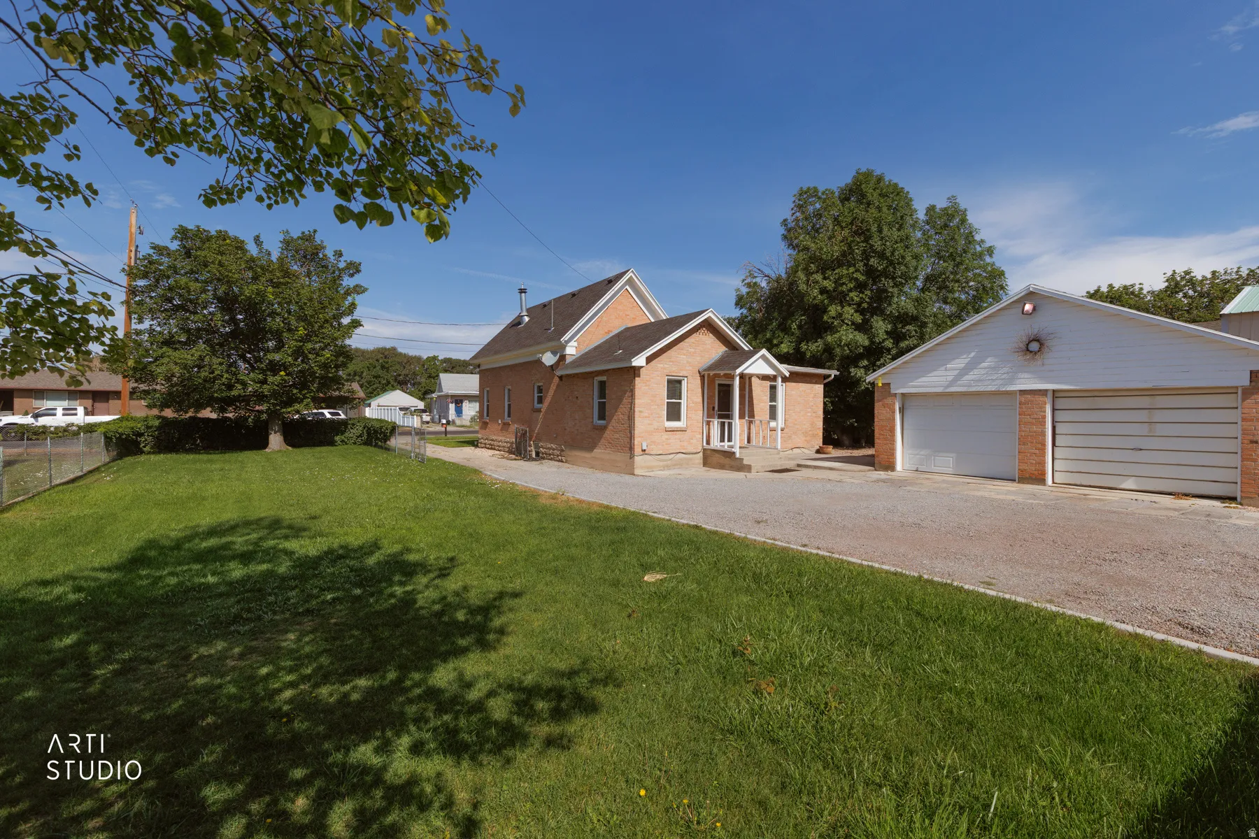Brick exterior home with a covered front porch and a detached two-car garage