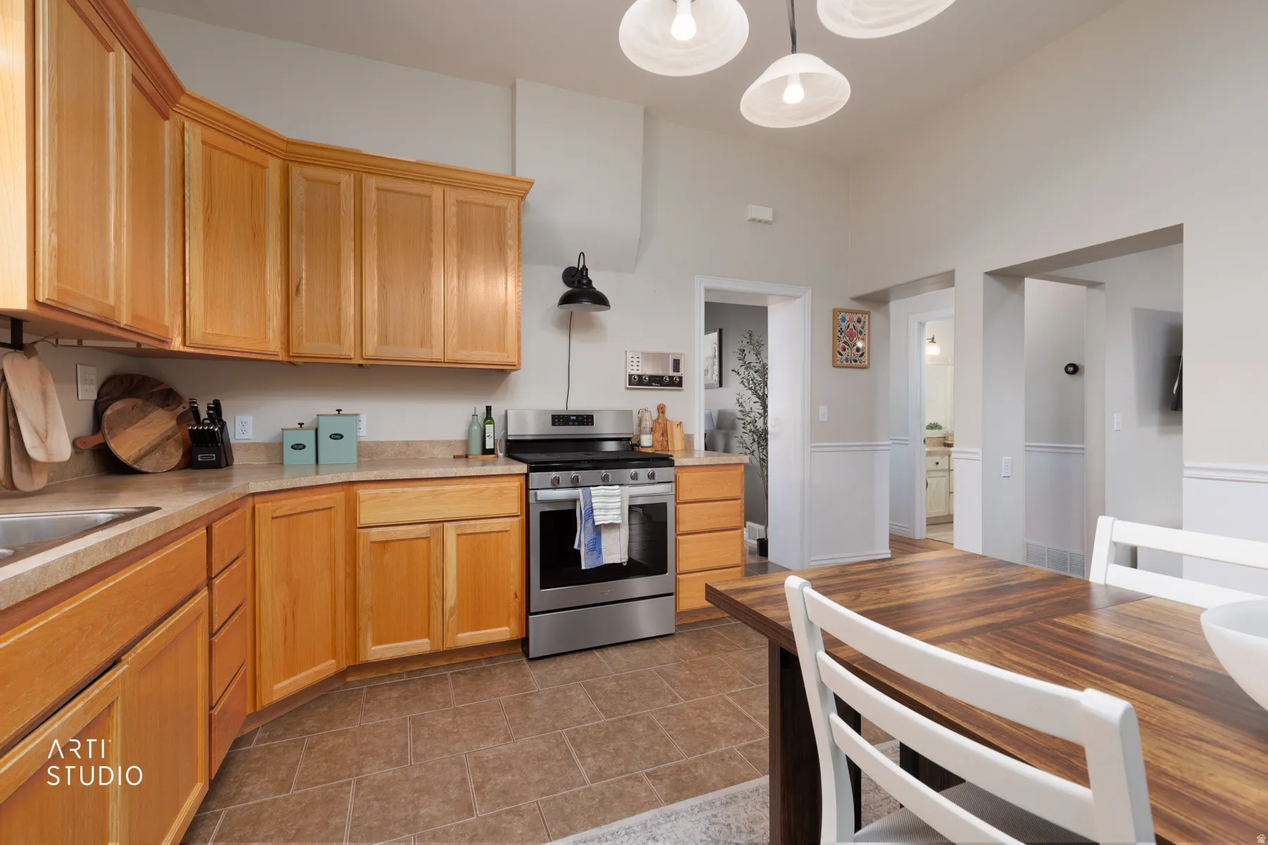 Kitchen featuring natural wood-finish cabinetry, a stainless steel range, and tile flooring