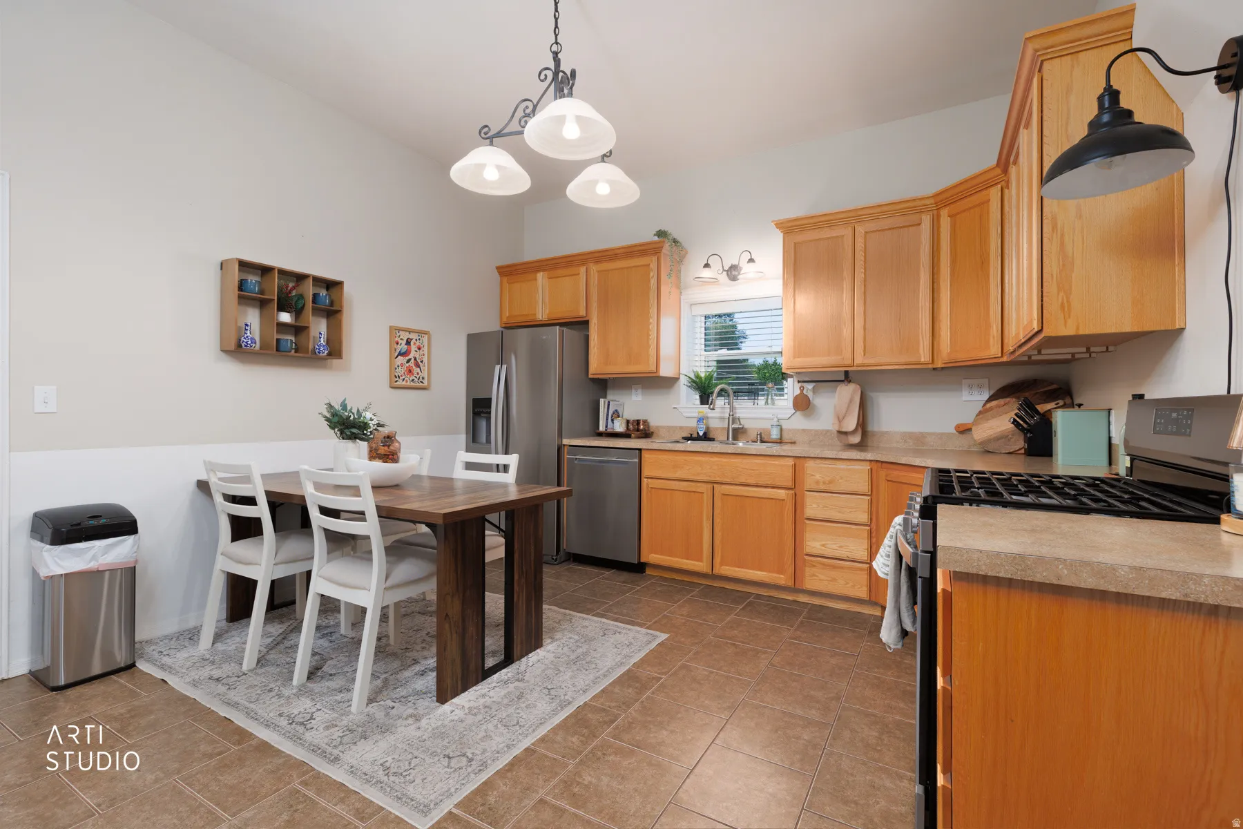 Full kitchen featuring light wood cabinetry, stainless steel appliances, and a gas range