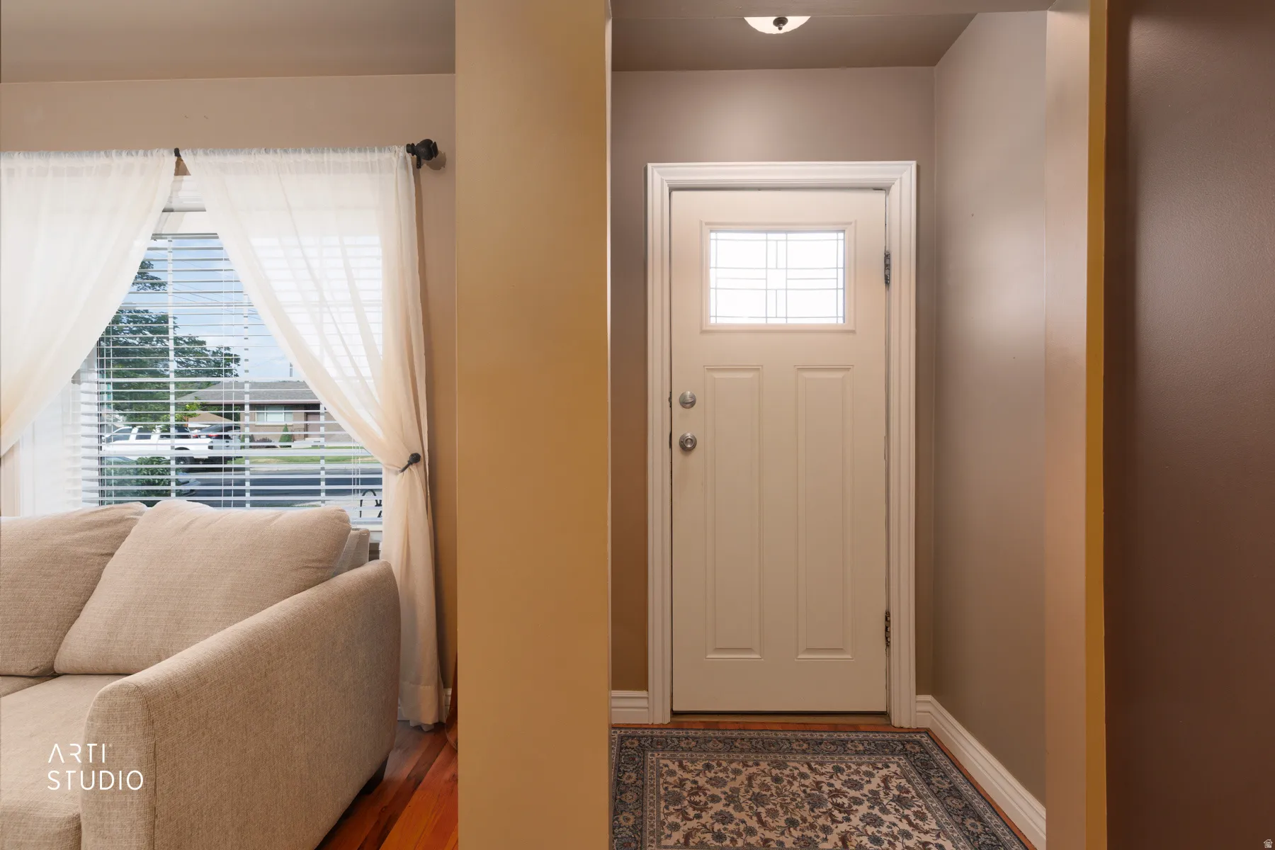 Entryway featuring a white door with decorative glass inserts, chrome hardware, and a ceiling-mounted light fixture