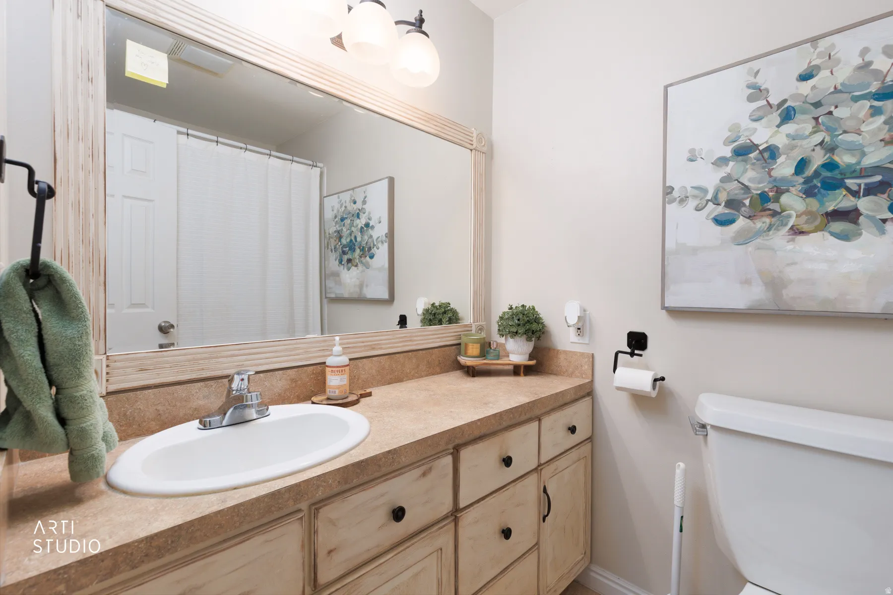 Bathroom featuring a vanity with an integrated sink, a rectangular mirror with a decorative frame, and a wall-mounted light fixture