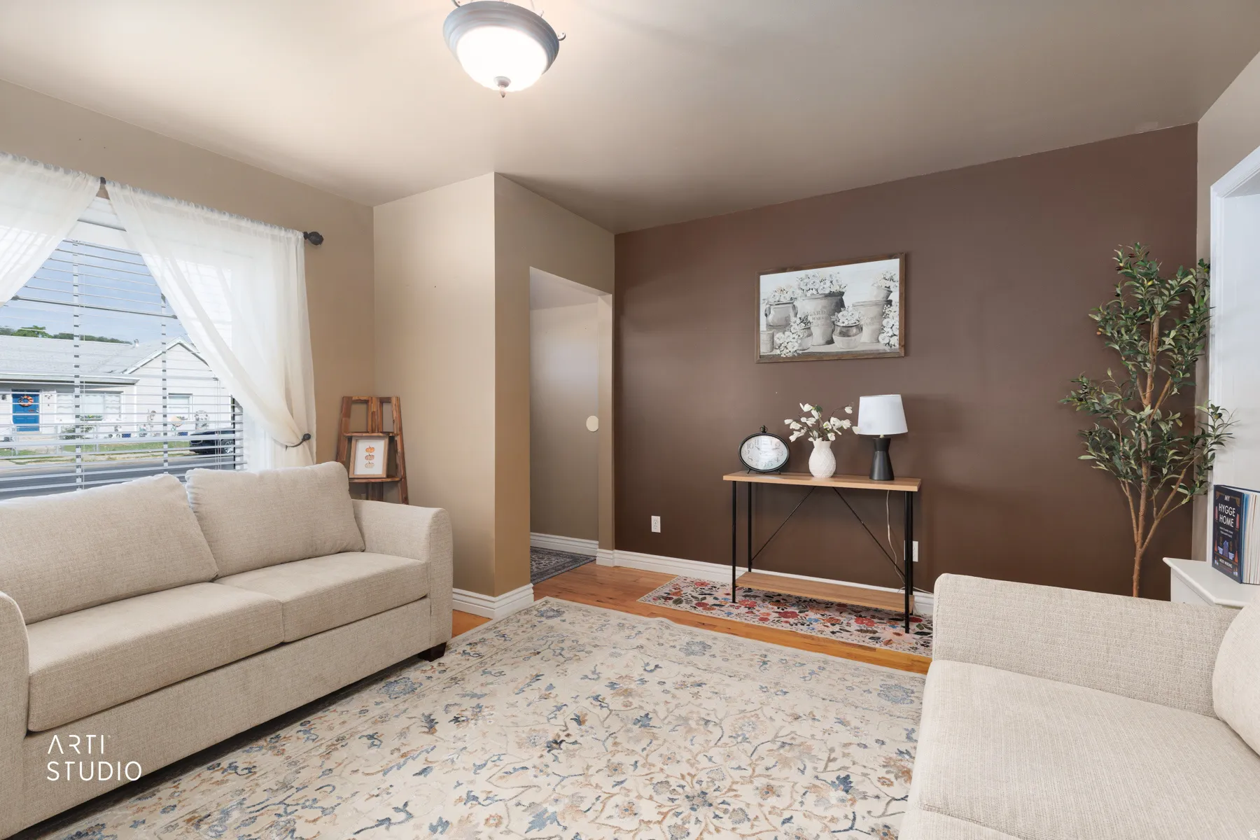 Living area featuring light beige walls and a contrasting brown accent wall
